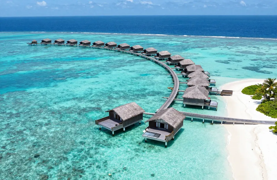 Vista aérea de bungalows sobre el agua y laguna turquesa en las Islas Maldivas.