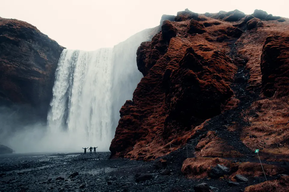 Cascada Skógafoss en la Costa Sur de Islandia con personas al pie